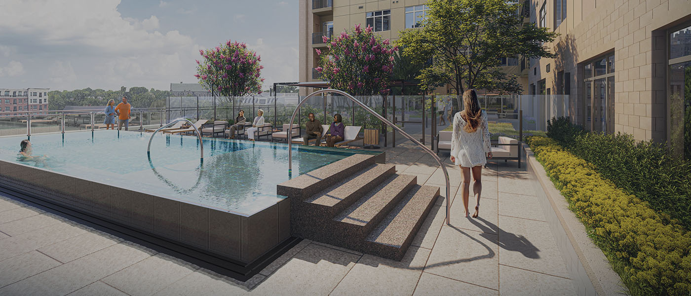 Outdoor pool area at an apartment complex, with people lounging on chairs, a person swimming, and a woman walking toward the pool. There are trees, landscaping, and buildings in the background.